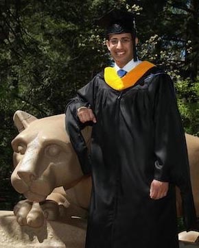 a man wearing cap, gown, and masters hood stands next to the nittany lion statue