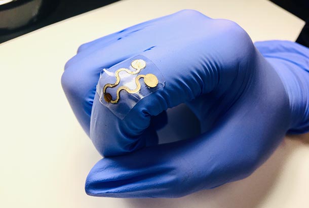 gloved hand wearing a flexible sensor over knuckle