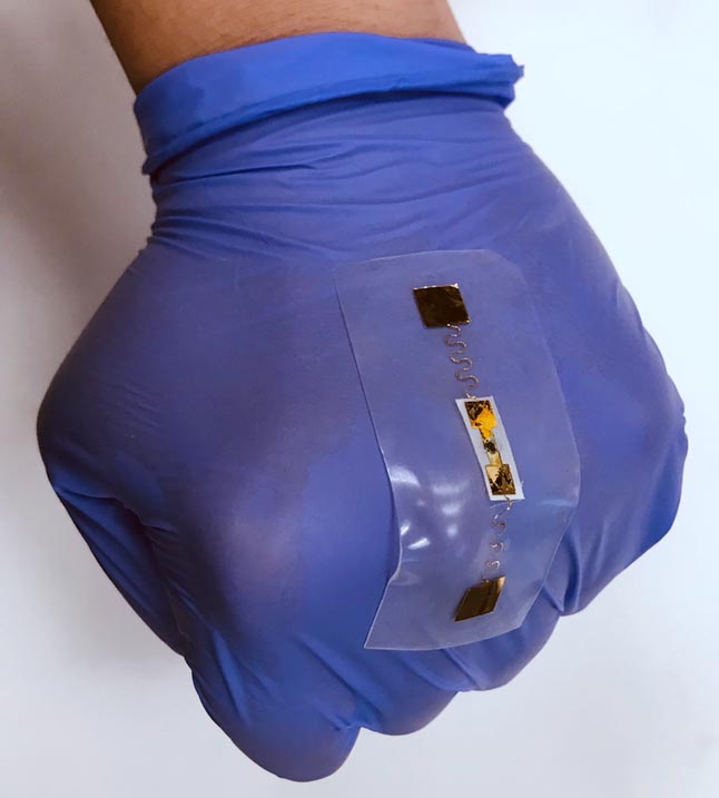 gloved hand wearing a flexible sensor on top