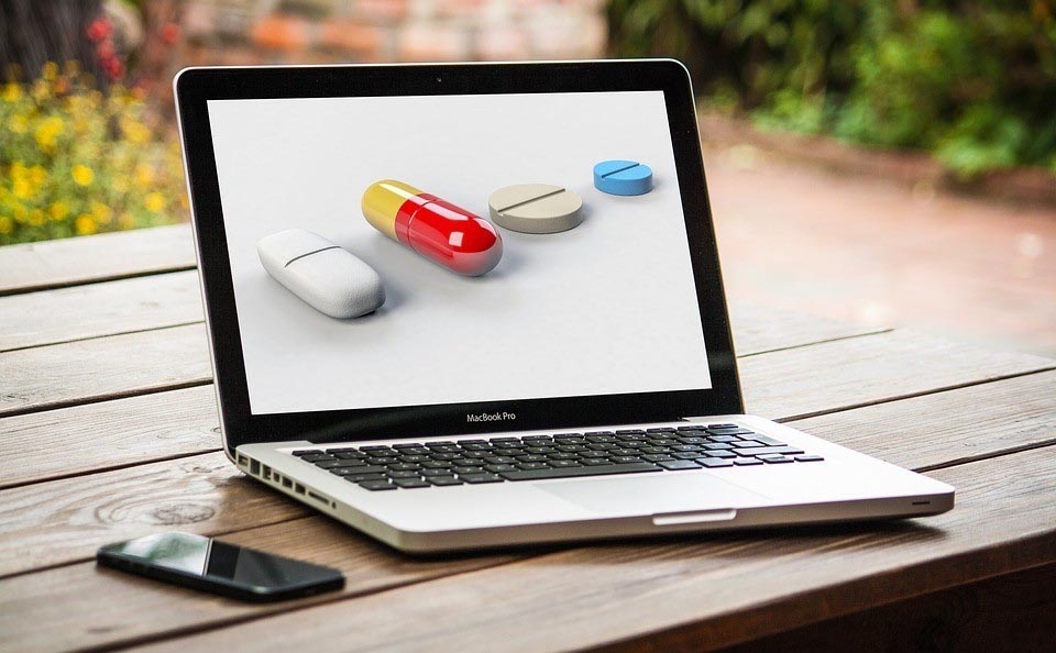 open laptop with images of large pills on the screen