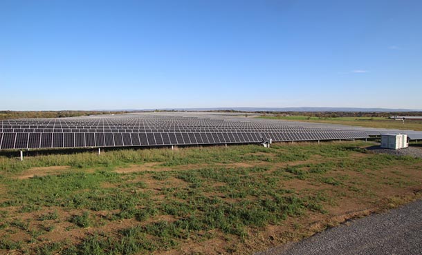 a large array of solar panels in an open field