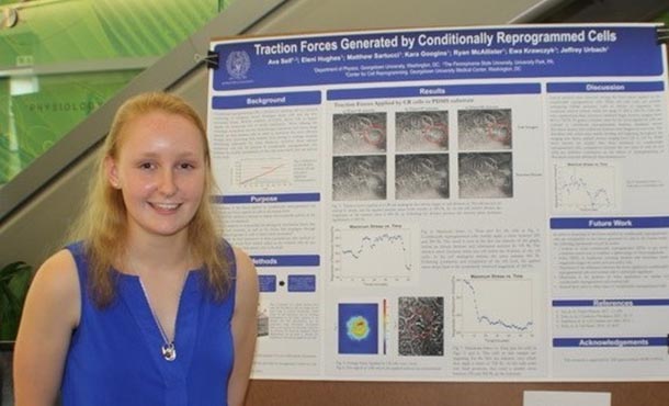 a woman stands next to a research poster