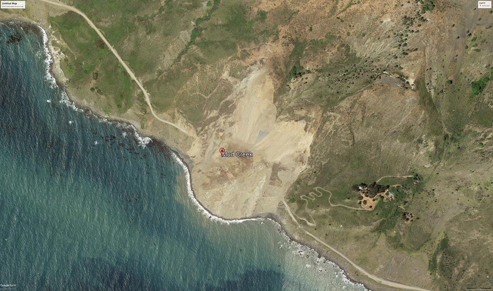 satellite image of a landslide along a coastal road