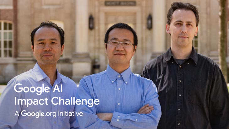 three researchers stand in front of a building