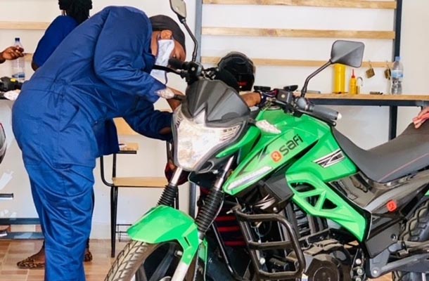 Two people work on a motorcycle.