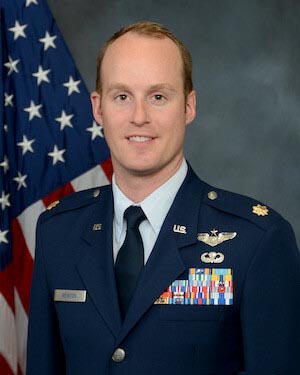 headshot of a man wearing u s airforce uniform with the american flag in the background