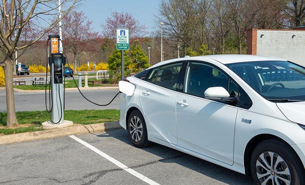 a white car plugged into an outdoor electric vehicle charging station