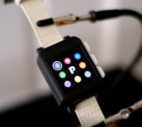 A square electronic watch with nine colored symbols. 