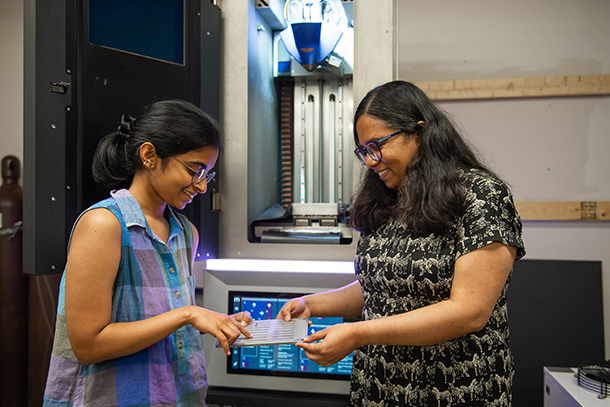 two people examine equipment in research lab