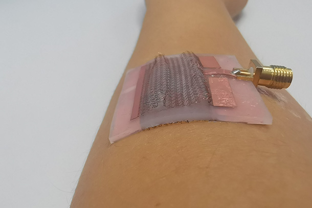  A electronic patch is shown on a human forearm.