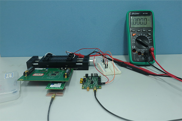 A matrix of wiring, motherboards and a cell phone are shown on a lab table