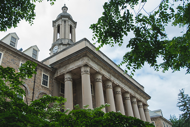 photo of Old Main at Penn State with tree branches framing the photo