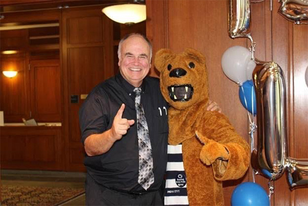 Mike Erdman stands with the Nittany Lion mascot, each holding up their fingers in "#1" gestures.