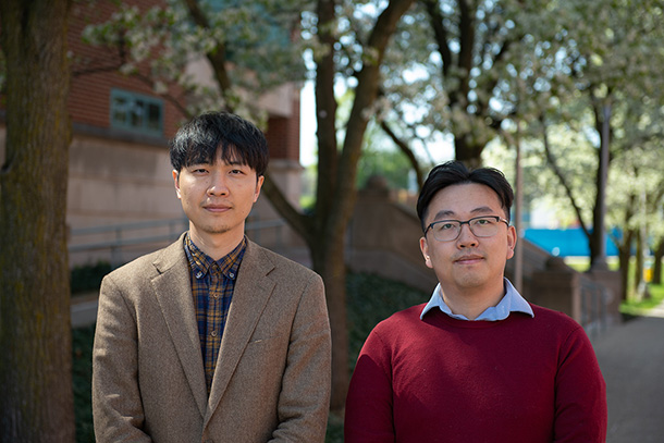 Two men stand outside. 