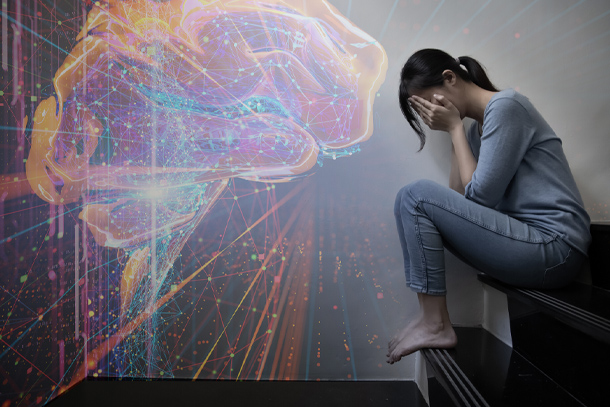 On the right side of the image, a person sits on a step with her face in her hands. A digital rendering of a brain is projected on the left side of the image.
