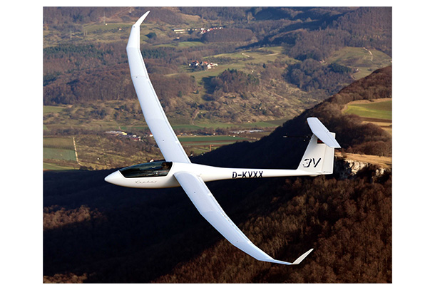 A sailplane above rolling green hills