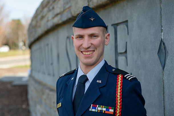 Portrait of a man in a U.S. Air Force uniform in front of a stone Penn State sign