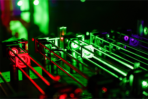 Small metal tubes are lit up by red and green lights. 