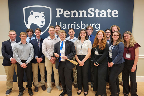 A group of students stands in front of a Penn State Harrisburg sign
