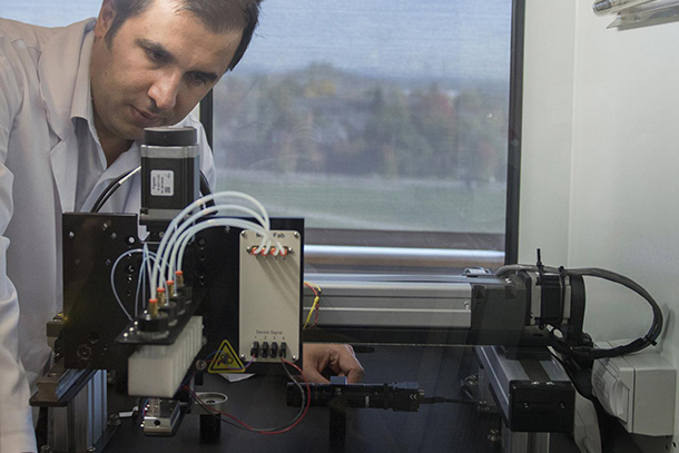 researcher works with bioprinting equipment in a lab