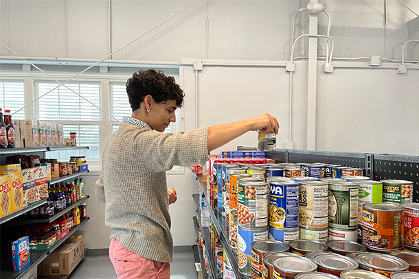 student stocked canned food at local food pantry