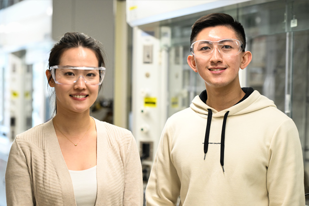  Two individuals wearing safety glasses pose in a lab.