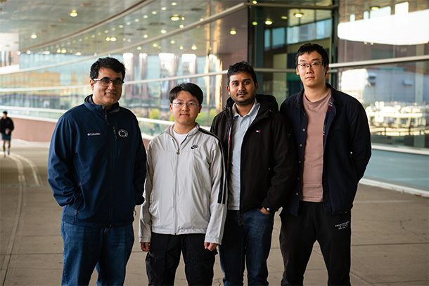 Four people pose for a portrait photo.