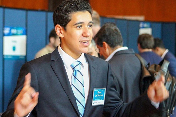 An individual in a suit speaking at a conference