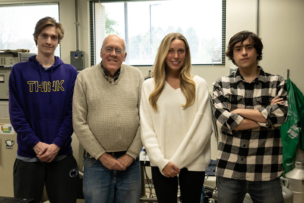 Four individuals pose for a photo in a lab setting.