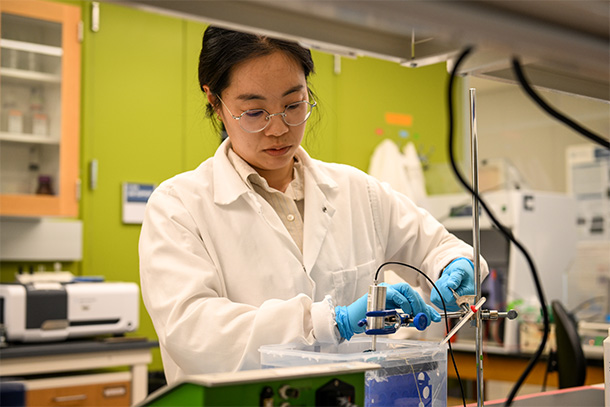  individual wearing white lab coat working in a lab 