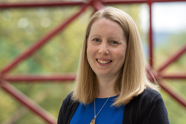 outdoors headshot of professor smiling for camera