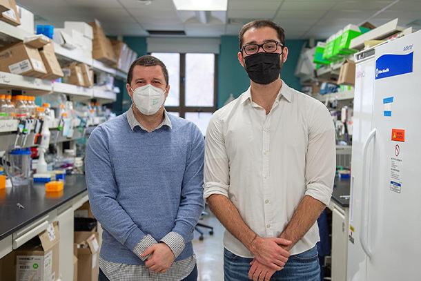 two people, both wearing face masks, stand side by side for photo.