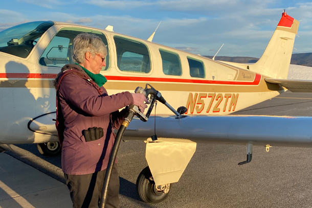 Person putting fuel into a small aircraft at a local airport
