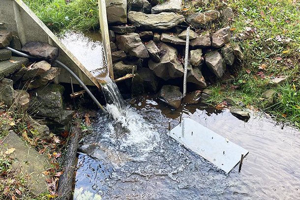 aerial view of waterfall with equipment in water. 