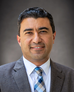 headshot of a person in a suit and tie.