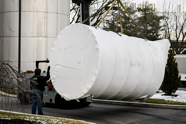 A large cylinder container being moved by a lift 