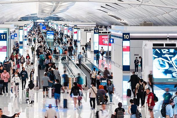 Crowds and groups of people moving through an airport.