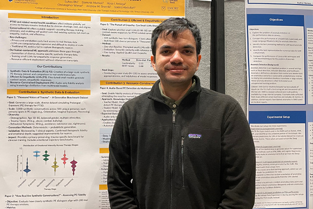 an individual poses in front of a poster