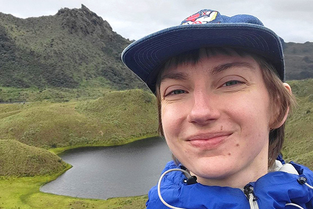 A dual degree environmental engineering and biogeochemistry graduate student stands for a photo outdoors.