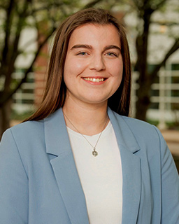 A headshot of an individual posing outdoors
