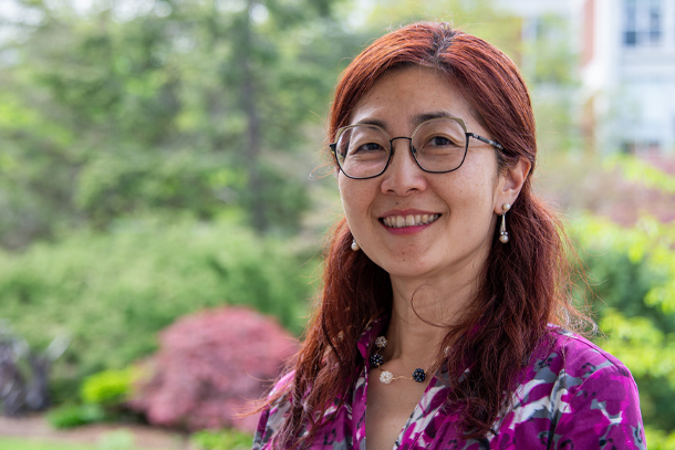 A professional headshot of an individual outdoors.